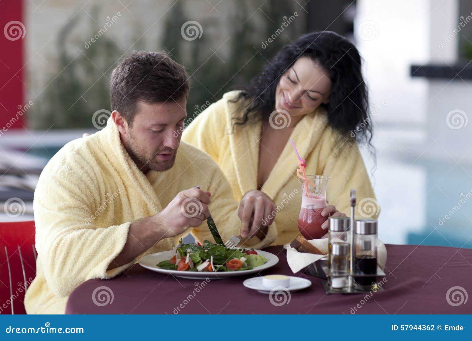 Cute Couple In Bathrobes Having Breakfast Together At