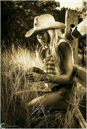 Country Girl In The Field Leaning Against A Wooden Fence Country