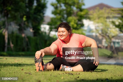 Asian Overweight Woman Exercising Stretch Alone In Public Park In